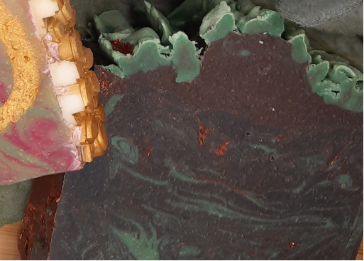 Handcrafted soap bars with decorative designs on a wooden surface